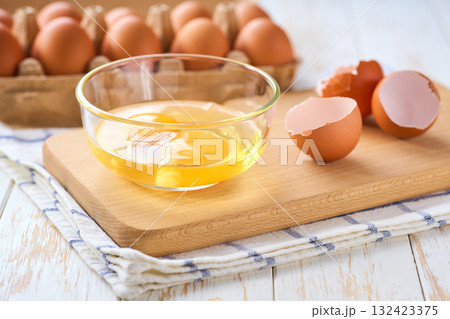 Cracked raw eggs on a light-colored kitchen table, selective focus. Cracked raw eggs on a light-colored kitchen table, selective focus. 132423375