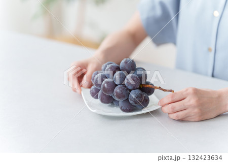 フルーツのブドウを食べる女性（ピオーネ） 132423634