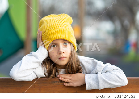 Serious girl in yellow cap with freckles looking Serious girl in yellow cap with freckles looking 132424353