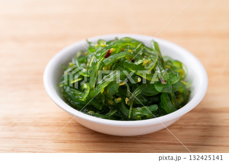 Wakame seaweed salad with sesame seed in a bowl on wooden background 132425141