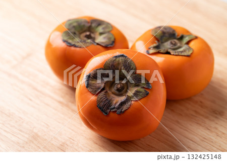 Ripe persimmon fruit on wooden background, Autumn fruit Ripe persimmon fruit on wooden background, Autumn fruit 132425148