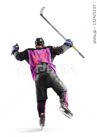Hockey player in action. Hockey champion seen rear view. A very emotional hockey player with a stick and puck in his hands. Isolated. Sports emotions 132425237