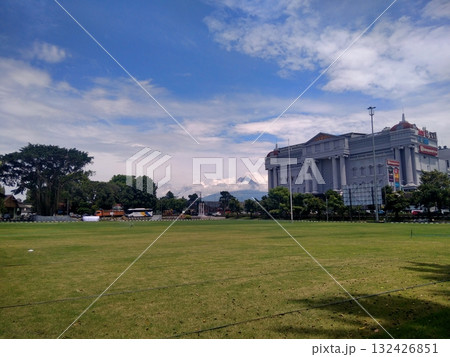 Large Green Field with Neoclassical Government Building Under Blue Sky Large Green Field with Neoclassical Government Building Under Blue Sky 132426851