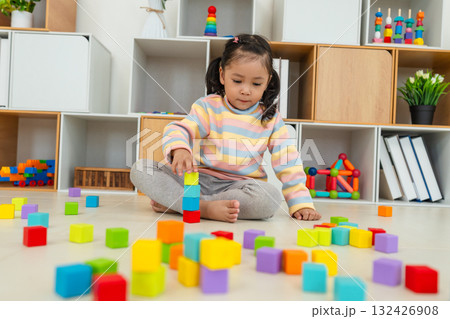toddler girl playing block toy to stacks building cubes at home toddler girl playing block toy to stacks building cubes at home 132426908