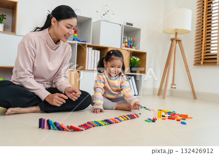 toddler girl and mother playing colorful wooden block toy or domino game together 132426912