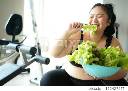 Asian woman eating healthy food salad before fitness exercise for lose weight. Asian woman eating healthy food salad before fitness exercise for lose weight. 132427475