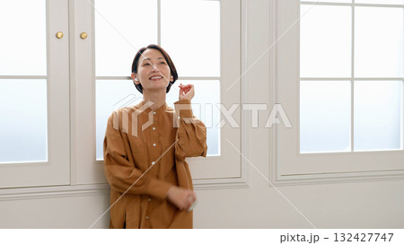 窓際で音楽やラジオを聴いている女性 132427747