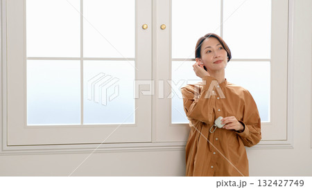 窓際で音楽やラジオを聴いている女性 132427749