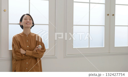 窓際で音楽やラジオを聴いている女性 132427754