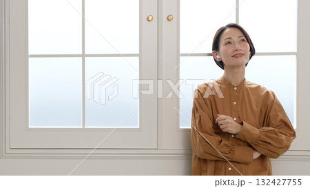 窓際で音楽やラジオを聴いている女性 窓際で音楽やラジオを聴いている女性 132427755