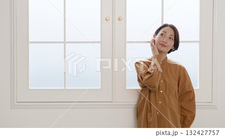 窓際で音楽やラジオを聴いている女性 窓際で音楽やラジオを聴いている女性 132427757
