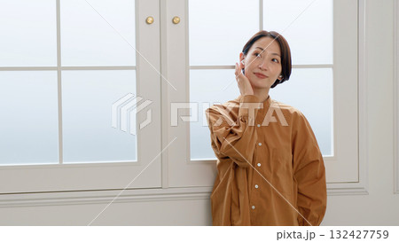 窓際で音楽やラジオを聴いている女性 窓際で音楽やラジオを聴いている女性 132427759