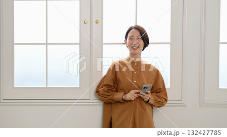 窓際で電話　女性　イメージ 132427785