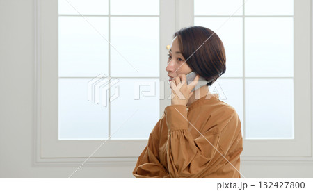 窓際で電話　女性　イメージ 132427800
