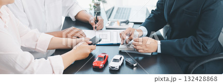 Panorama of businessman counting cash during car loan contract signing with vehicle models, key and documents on desk, concept of auto finance, leasing, insurance and payment. auto finance, leasing. 132428868