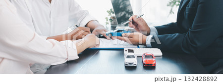 Panorama view of car loan agreement signing with dealer presenting vehicle model, customer using calculator at office desk, concept of auto finance, leasing, insurance and business contract. 132428892