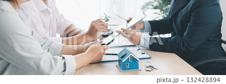 Panorama view of business meeting with miniature house model on desk, real estate contract signing, property investment, mortgage loan agreement and financial planning concept. mortgage loan agreement Panorama view of business meeting with miniature house model on desk, real estate contract signing, property investment, mortgage loan agreement and financial planning concept. mortgage loan agreement 132428894