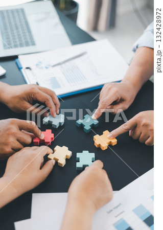 Business teamwork concept with people holding wooden puzzle pieces together, symbol of collaboration, strategy, problem solving, partnership and corporate success in modern office. business teamwork. 132428972