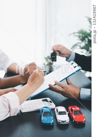 Customer receiving car key from dealer after signing contract, successful auto purchase and finance agreement at office desk, concept of vehicle loan, leasing, insurance or ownership. vehicle loan. Customer receiving car key from dealer after signing contract, successful auto purchase and finance agreement at office desk, concept of vehicle loan, leasing, insurance or ownership. vehicle loan. 132428987
