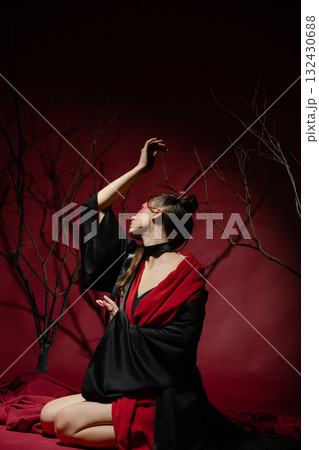 Woman poses elegantly in traditional Japanese attire within a studio setting 132430688