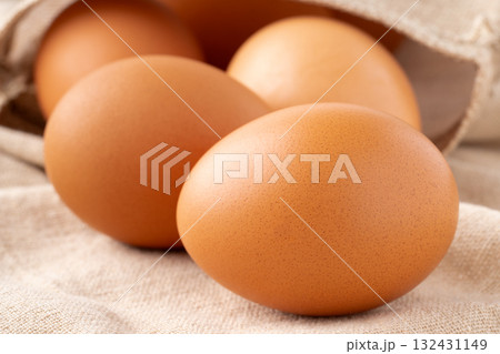 布の上に置かれた鶏の卵（赤玉）のクローズアップ 132431149