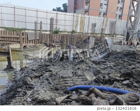 Construction site mud foundation work rebar concrete form urban building worker steel wet ground 132431816