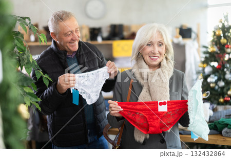 Mature couple choosing panties in the store against the background of the Christmas tree 132432864