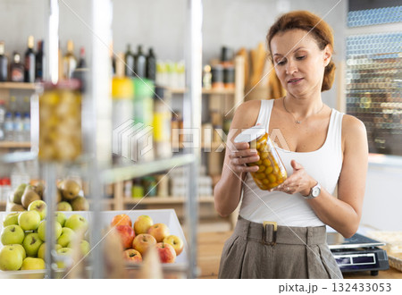 Adult woman choosing olives in grocery store 132433053