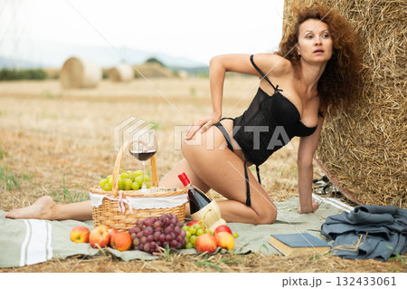 Sensual woman in black lingerie kneeling by hay bale Sensual woman in black lingerie kneeling by hay bale 132433061
