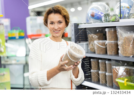 Interested woman choosing nutritious turtle food in pet store 132433434