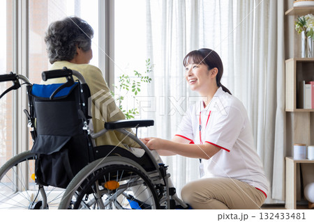 車椅子の高齢者と介護士 132433481