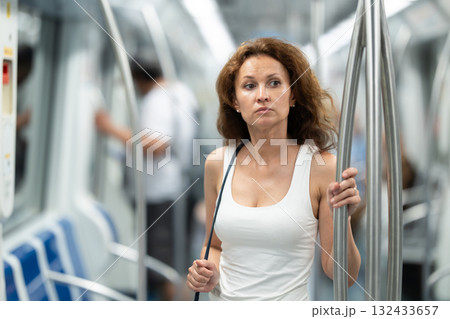Portrait of woman passenger standing inside train at metro wagon 132433657