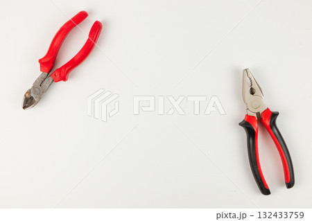 Two pairs of pliers on a clean work surface in a well-lit area Two pairs of pliers on a clean work surface in a well-lit area 132433759