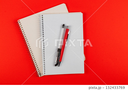 Stationery set with notebooks and pens on a bright red background 132433769