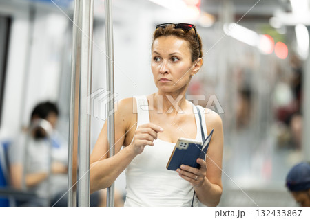 Portrait of female passenger using tablet in subway car Portrait of female passenger using tablet in subway car 132433867
