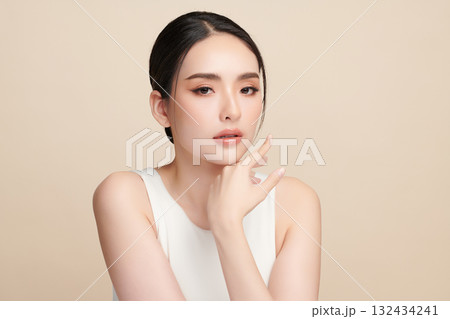 A beautiful young Asian woman with clean, fresh skin against a beige background. Skincare, facial treatment, cosmetology, beauty, and spa. An elegant portrait of an Asian woman. A beautiful young Asian woman with clean, fresh skin against a beige background. Skincare, facial treatment, cosmetology, beauty, and spa. An elegant portrait of an Asian woman. 132434241