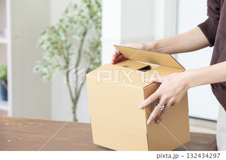 段ボールで荷造りする手元 132434297