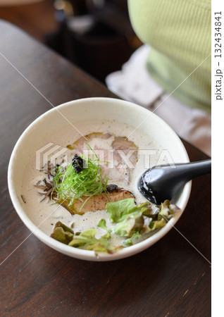 Close up view of partially eaten gourmet ramen bowl with pork and rich broth inside modern japanese restaurant. leftover delicious meal evokes culinary satisfaction Close up view of partially eaten gourmet ramen bowl with pork and rich broth inside modern japanese restaurant. leftover delicious meal evokes culinary satisfaction 132434841