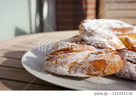 Traditional Spanish ensaimadas with powdered sugar on a plate 132435116