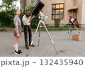 Man observes sky using telescope during astronomy session 132435940
