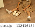 Young girl in polka dot dress holding beige shoes 132436184