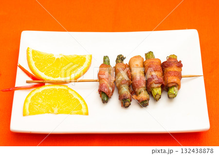 Bacon-Wrapped Asparagus Skewers with Orange Slices 132438878