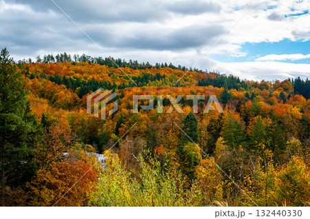 Autumn countryside near Luhacovice, Czech Republic, with colorful forests, meadows, and gentle hills in shades of red, orange, and yellow at the beginning of fall. 132440330