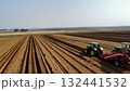 Aerial View of Tractors Preparing Farmland for Planting Season 132441532