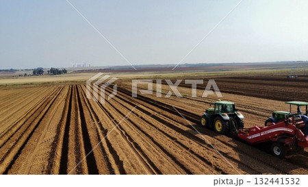Aerial View of Tractors Preparing Farmland for Planting Season 132441532