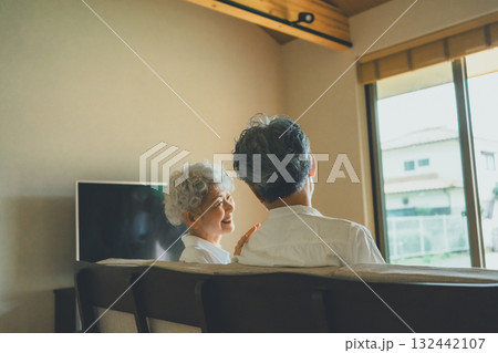 リビングのソファで寛ぐ老夫婦 132442107