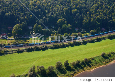 Aerial view of landscape with freight train on railway, green fields and forest Aerial view of landscape with freight train on railway, green fields and forest 132442834