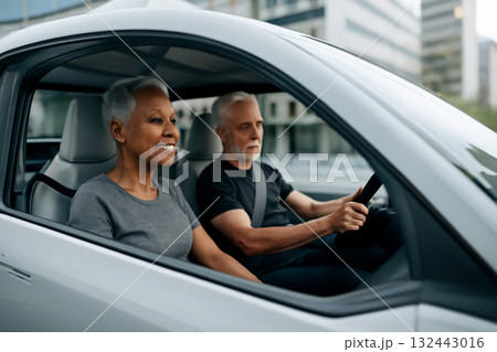 AI generated photo of seniors enjoying a ride in a futuristic vehicle through a sleek city. The image captures a sense of comfort, technology, and modern lifestyle with a vibrant urban backdrop. 132443016