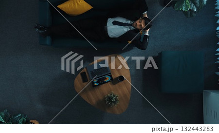 Top view of business man working om laptop while lying on sofa. Directorate. Top view of business man working om laptop while lying on sofa. Directorate. 132443283