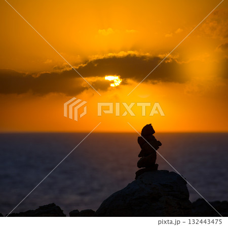 Stacked stones for a wish on Mediterranean sunset Stacked stones for a wish on Mediterranean sunset 132443475